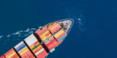 Container cargo ship, import export business and logistics, aerial top view. Water transport, international freight shipping, commercial trade and transportation in the open sea